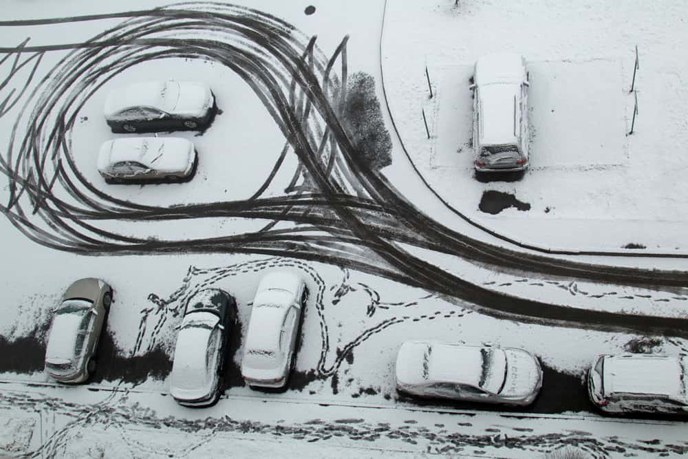wild car tracks in snow covered parking lot