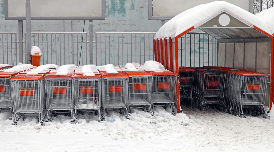 snow covered shopping carts and parking lot